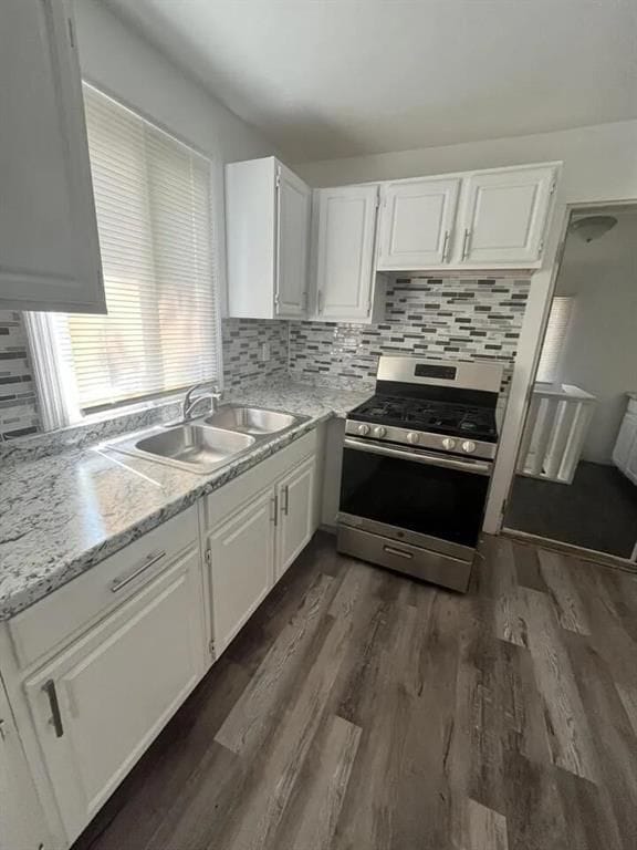 kitchen with white cabinets, dark hardwood / wood-style flooring, sink, and stainless steel gas range oven