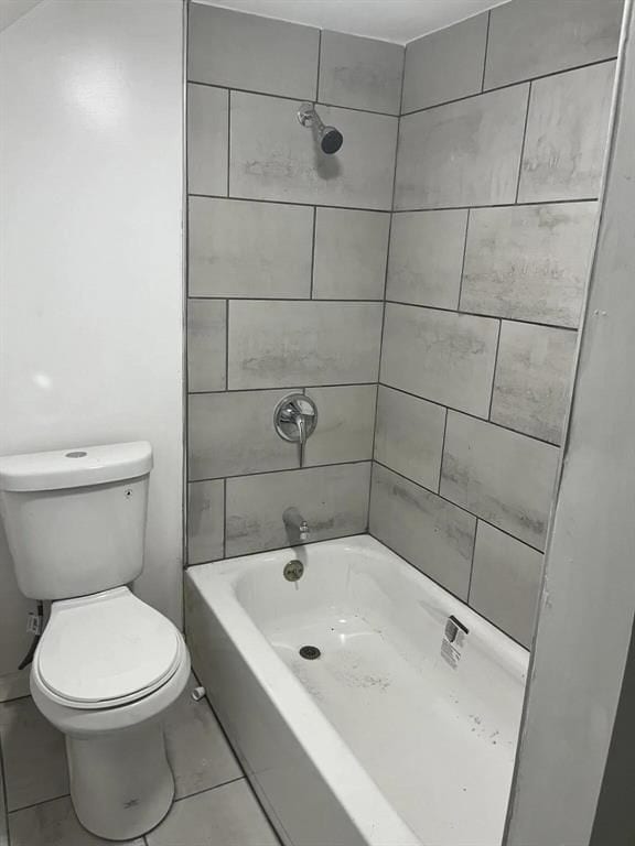 bathroom with tiled shower / bath combo and toilet