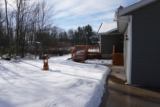 yard layered in snow featuring a wooden deck