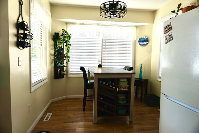 dining space with dark hardwood / wood-style flooring and a chandelier