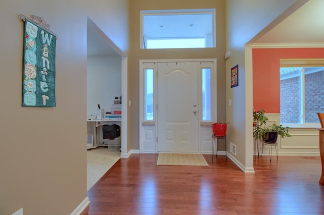 entrance foyer with crown molding, hardwood / wood-style flooring, and plenty of natural light