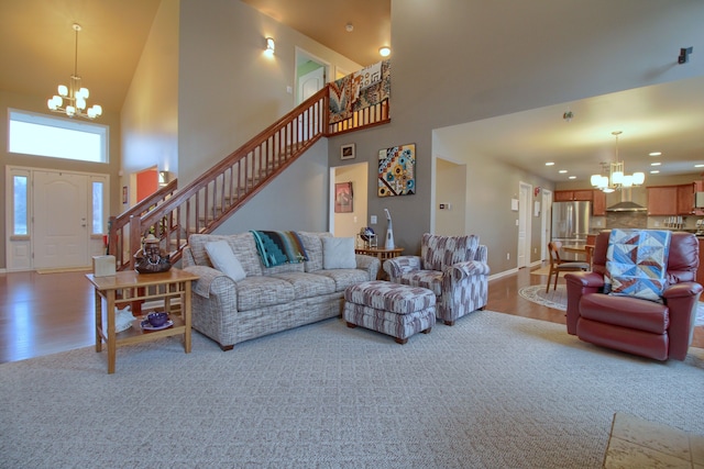 living room featuring a high ceiling, hardwood / wood-style floors, and a chandelier