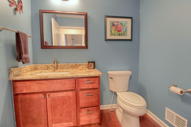 bathroom with vanity, hardwood / wood-style floors, and toilet