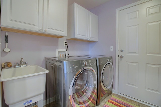 clothes washing area featuring sink, cabinets, and washing machine and clothes dryer