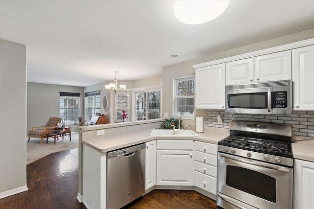 kitchen featuring white cabinetry, appliances with stainless steel finishes, sink, and kitchen peninsula