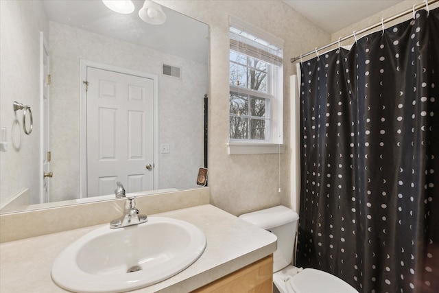 bathroom with walk in shower, sink, and toilet