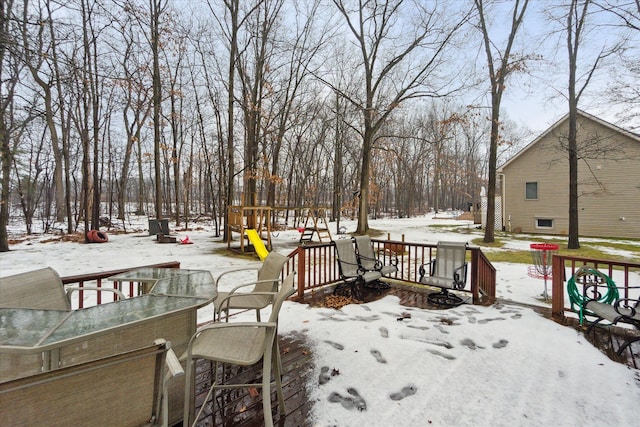 snow covered deck featuring a playground