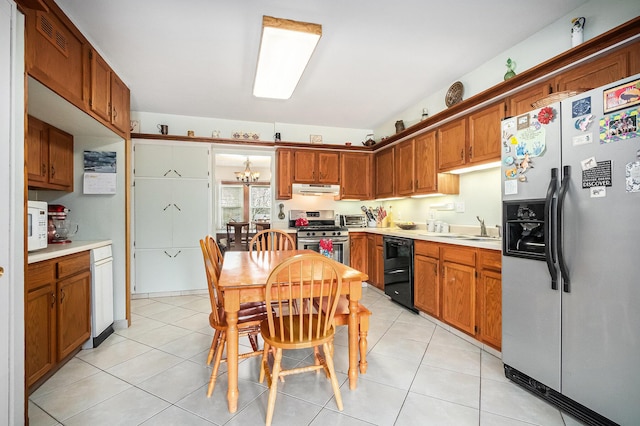 kitchen with sink, light tile patterned floors, stainless steel appliances, and a chandelier