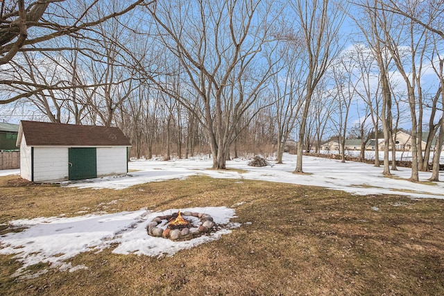 snowy yard featuring a shed