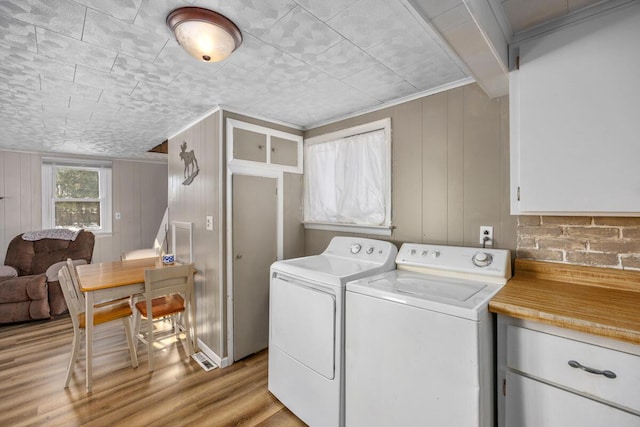 laundry room with cabinets, separate washer and dryer, and light wood-type flooring