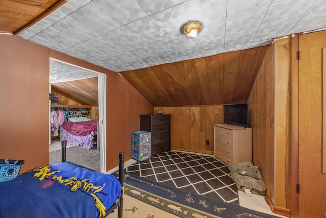 bedroom featuring wood ceiling, lofted ceiling, a closet, and wood walls