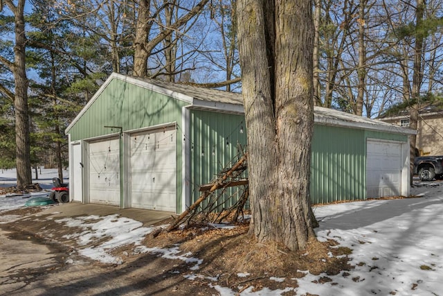 snow covered structure featuring a garage