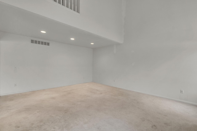 unfurnished room with a towering ceiling and light carpet