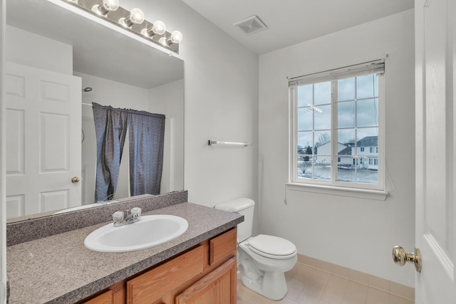 bathroom featuring vanity, tile patterned flooring, and toilet