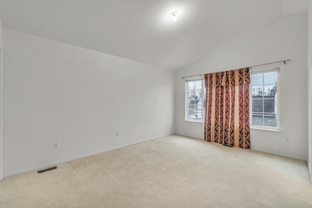 empty room with lofted ceiling and light carpet