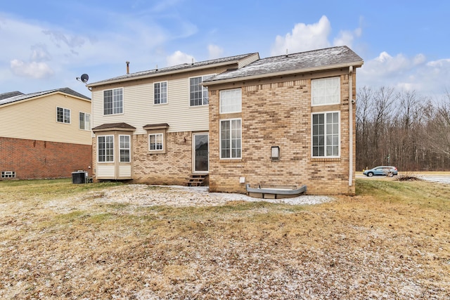 back of property featuring a yard and central AC unit