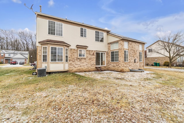 rear view of property with central AC unit and a lawn