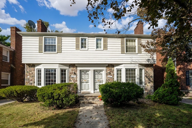 colonial home featuring a front yard