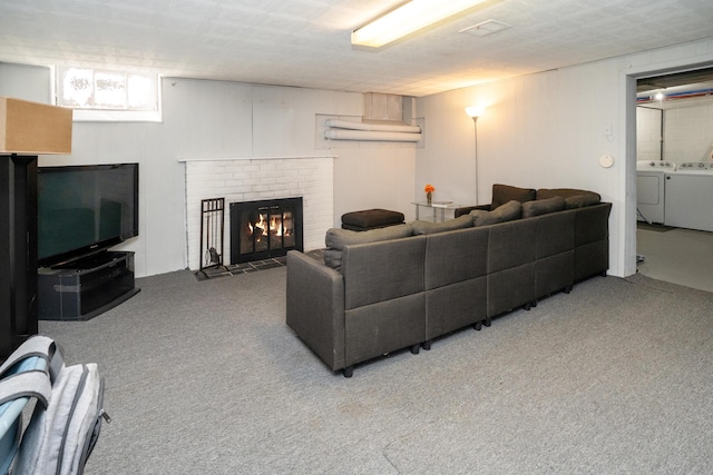 carpeted living room with a fireplace and washer and dryer