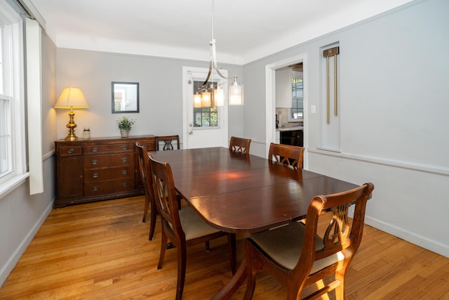 dining space featuring an inviting chandelier and light wood-type flooring