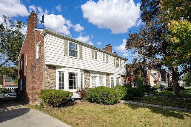 colonial inspired home with a front lawn