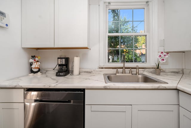 kitchen with dishwasher, sink, white cabinets, and light stone counters