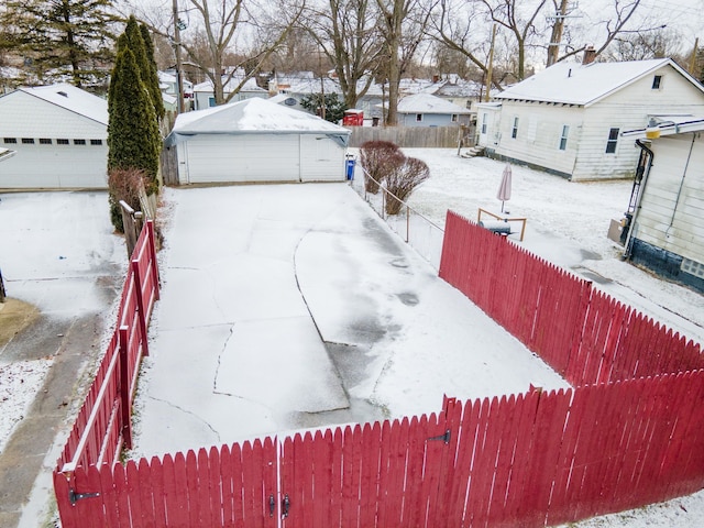 snowy yard featuring an outbuilding and a garage