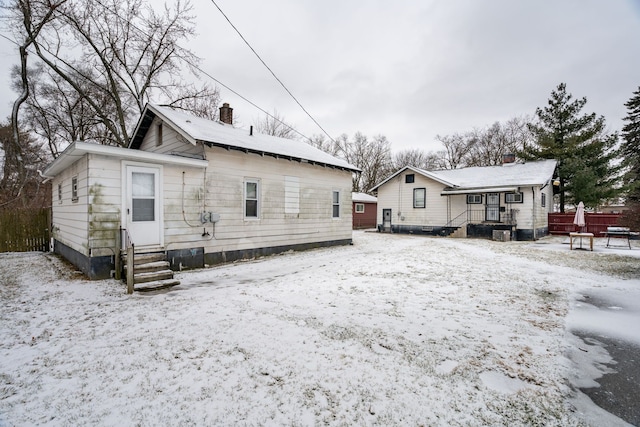 view of snow covered back of property