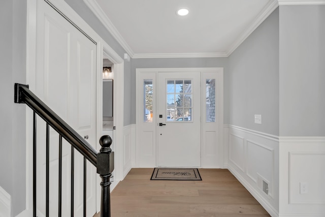 foyer featuring ornamental molding and light wood-type flooring