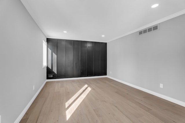 spare room featuring light hardwood / wood-style flooring and ornamental molding