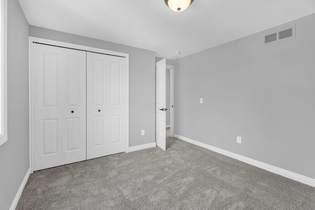 unfurnished bedroom with a closet and light carpet