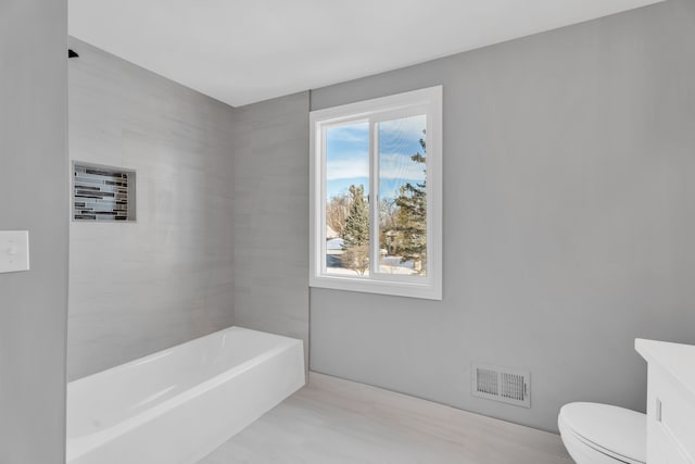 bathroom with vanity, a bathtub, and toilet