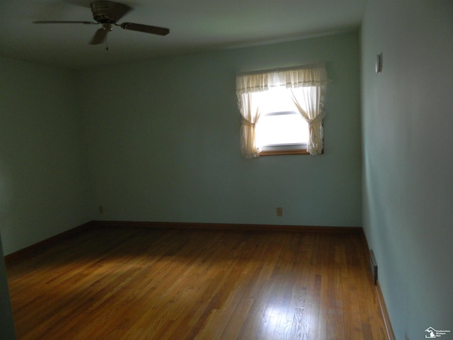 spare room featuring wood-type flooring and ceiling fan