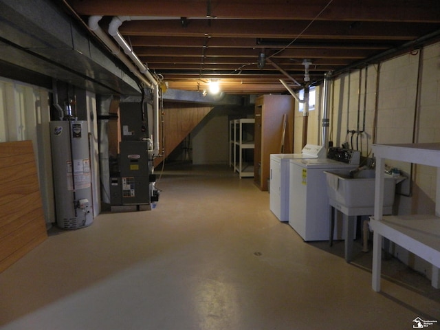 basement featuring gas water heater, sink, heating unit, and washer and clothes dryer