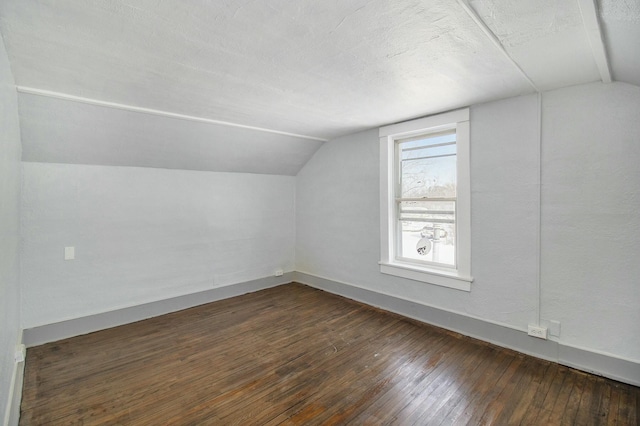 bonus room with lofted ceiling, a textured ceiling, and dark hardwood / wood-style flooring