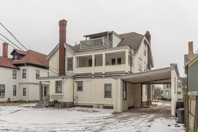 snow covered property with a balcony