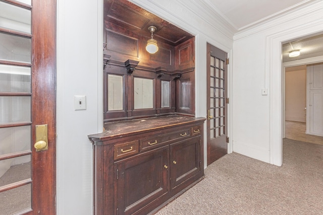 corridor featuring ornamental molding and light colored carpet