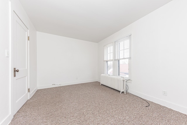 carpeted spare room with radiator heating unit