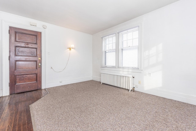 empty room with dark carpet and radiator heating unit