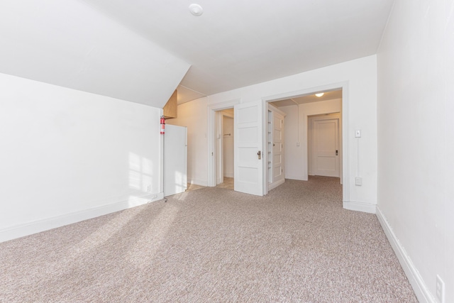 bonus room featuring carpet floors and vaulted ceiling