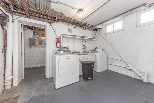 clothes washing area featuring electric panel and washer and dryer