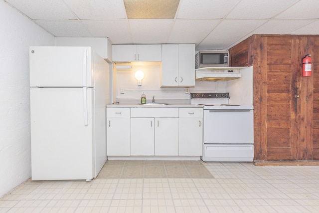 kitchen with sink, a paneled ceiling, white cabinets, and white appliances