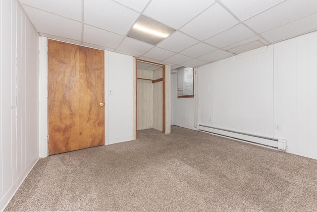 unfurnished bedroom featuring carpet floors, a paneled ceiling, and baseboard heating