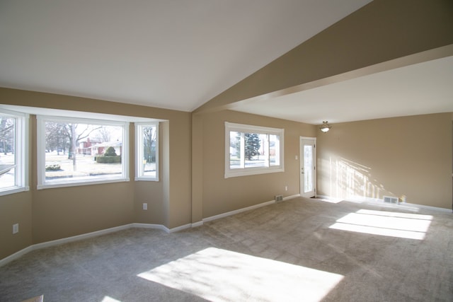 empty room featuring lofted ceiling and carpet flooring