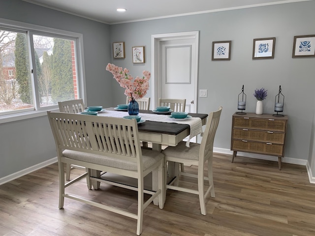 dining room with hardwood / wood-style flooring and ornamental molding