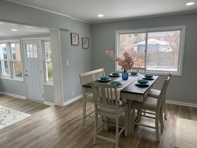 dining area with wood-type flooring and ornamental molding