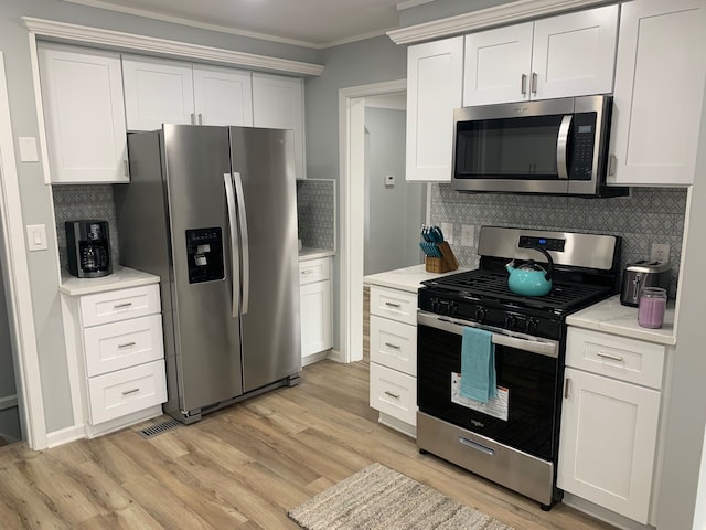 kitchen with white cabinetry, decorative backsplash, stainless steel appliances, crown molding, and light wood-type flooring