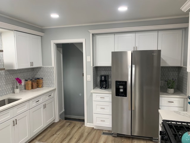 kitchen with white cabinetry, decorative backsplash, stainless steel fridge with ice dispenser, and light hardwood / wood-style flooring