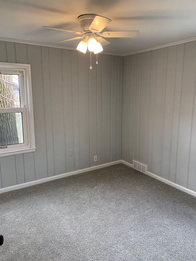 carpeted spare room featuring ceiling fan