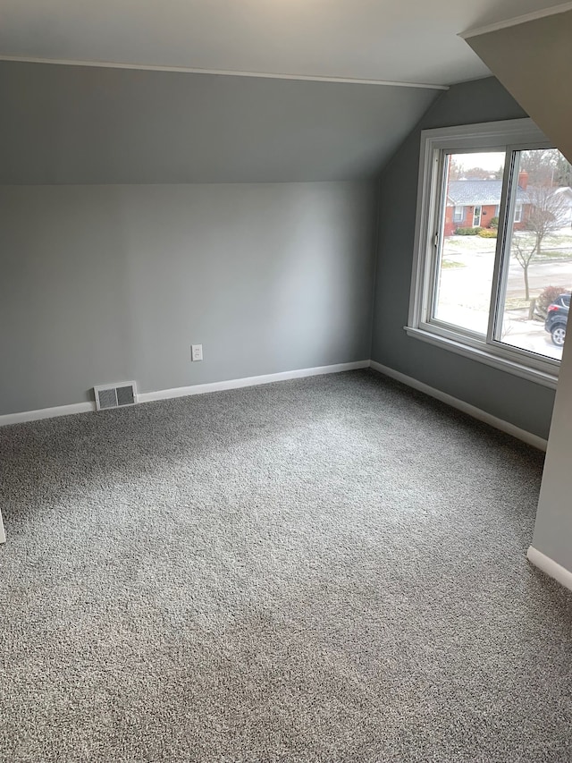 bonus room with vaulted ceiling and carpet flooring